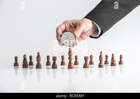 Unternehmen Vision und Richtung Konzept - Hand ein Geschäftsmann mit einem Kompass auf Schachfiguren auf weißem Schreibtisch mit Reflexion gelegt. Stockfoto