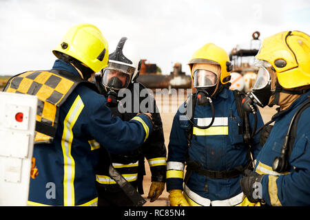 Feuerwehr Training, Feuerwehrleute mit Atemschutzgeräten hören von Supervisor Stockfoto