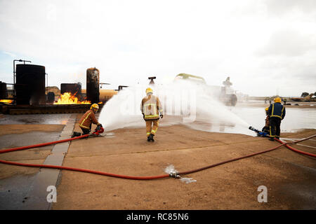 Feuerwehr Training, sprühen Wasser auf Feuer an Training Service Stockfoto