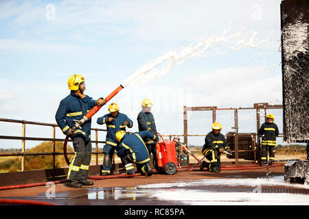 Feuerwehr Training, Feuerwehrleute spritzen Brandbekämpfung Schaum Training Service Stockfoto