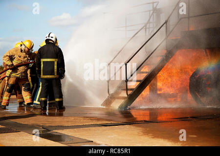 Feuerwehr Training, Feuerwehrleute sprühen Wasser bei Training Service Treppe Stockfoto