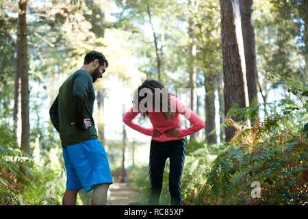 Erschöpft, männlichen und weiblichen Läufern eine Pause im Wald Stockfoto