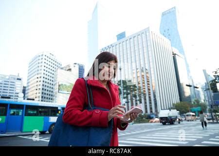 Geschäftsfrau mit Smartphone in Stadt, Seoul, Südkorea Stockfoto