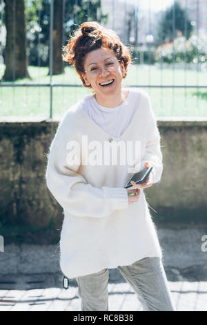 Lachende Frau, Handy in der Hand, Mailand, Italien Stockfoto