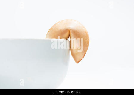 Fortune Cookies auf dem Rand der Schüssel für Nachtisch auf weißem Hintergrund Stockfoto