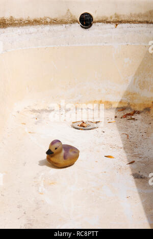 Kunststoff Ente in leeren Badewanne wird das Regenwasser für den Garten zu sammeln. Das Wasser hat während einer längeren Trockenperiode verwendet worden. Stockfoto