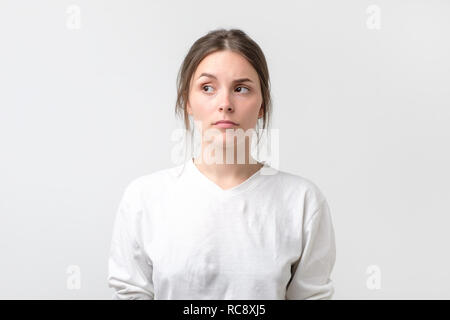 Zweifelnd Frau suchen mit Unglauben Ausdruck beiseite. Junge emotionale Frau vermuten, dass Ihr Mann oder Freund im Betrug. Stockfoto