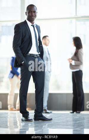 Schönen afrikanischen Geschäftsmann mit einer Gruppe von Geschäftsleuten für den Hintergrund. Stockfoto