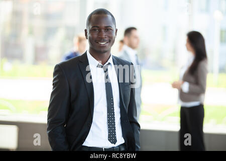 Schönen afrikanischen Geschäftsmann mit einer Gruppe von Geschäftsleuten für den Hintergrund. Stockfoto