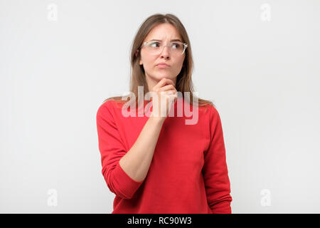 Zweifelnd Frau suchen mit Unglauben Ausdruck beiseite. Junge emotionale Frau vermuten, dass Ihr Mann oder Freund im Betrug. Stockfoto