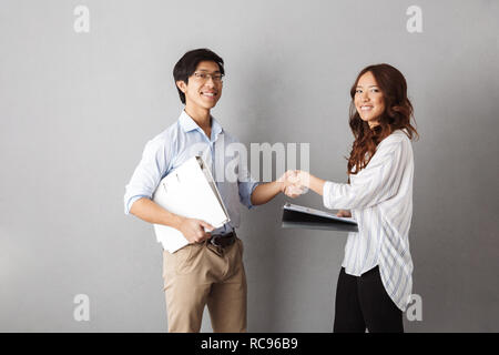 Happy Asian Business Paar zusammen Arbeiten mit Dokumenten über grauer Hintergrund Stockfoto