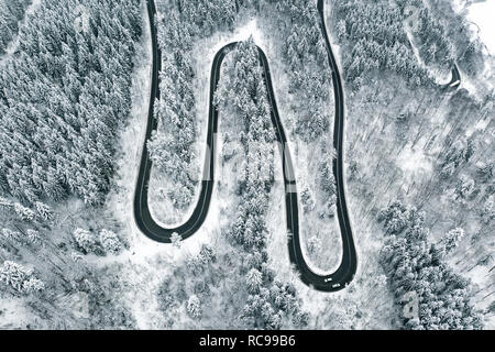 Biegen Straße in den Wald im Winter Stockfoto