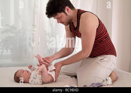 Junger Vater wickelt Baby Stockfoto