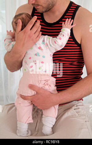 Junger Vater wickelt Baby Stockfoto