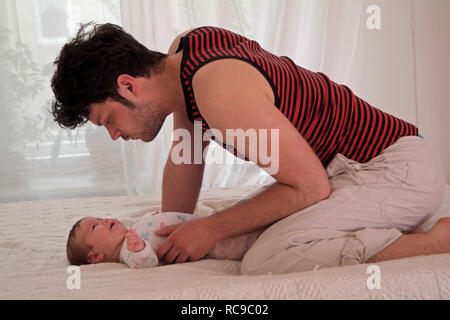 Junger Vater wickelt Baby Stockfoto