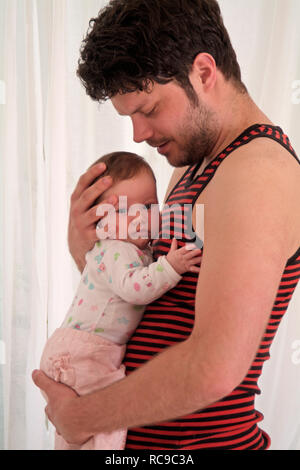 Junger Vater wickelt Baby Stockfoto