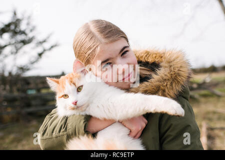 Mädchen kuscheln Katze im Feld Stockfoto