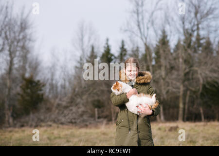 Mädchen kuscheln Katze im Feld Stockfoto