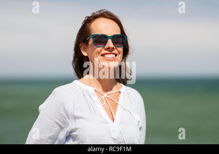 Glücklich lächelnde Frau mit Sonnenbrille auf Sommer Strand Stockfoto