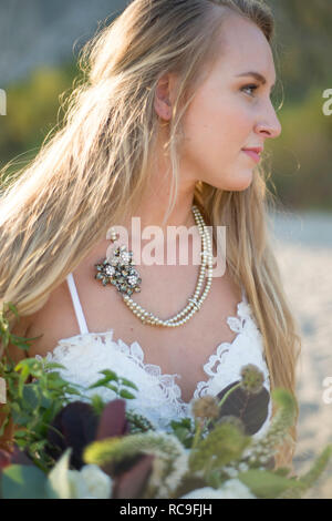 Braut mit Blumenstrauß am Strand Stockfoto