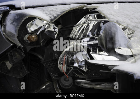 Gebrochene auto Licht Unfall. In der Nähe des beschädigten Scheinwerfer in einem vor dem Auto, im Winter. Stockfoto