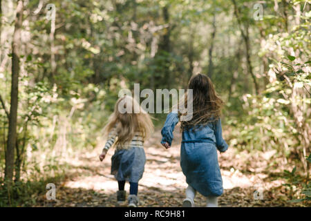 Schwestern in Wald läuft Stockfoto