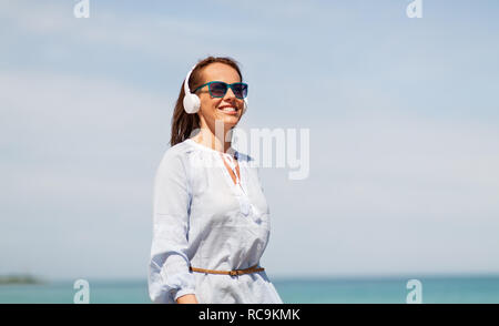 Frau mit Kopfhörer entlang Sommer Strand Stockfoto