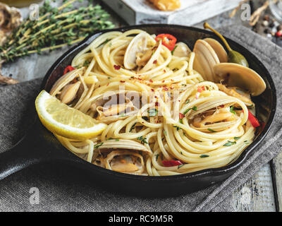 Pasta mit Meeresfrüchten, Muscheln Muscheln in der eiserne Pfanne teil, mit Zitrone und Gewürzen Stockfoto