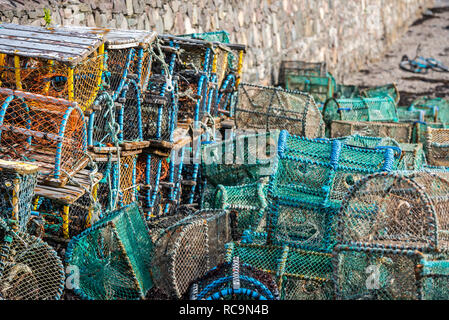 Hummer pots/Garnelen Reusen gegen die Hafenmauer im Plockton, Scottish Highlands, Schottland, UK gestapelt Stockfoto