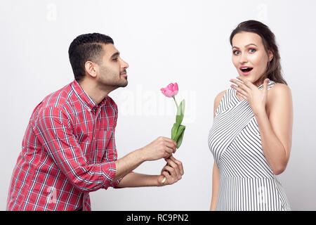 Seitenansicht mann Tulip, aufgeregt zu Frau. Portrait von stattlicher Mann in rot kariertem Hemd und schöne Frau in weiss gestreiftes Kleid stehen. indo Stockfoto