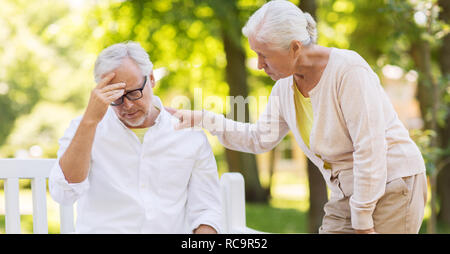 Ältere Menschen leiden unter Kopfschmerzen im Freien Stockfoto