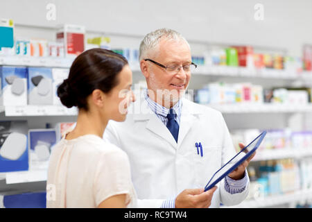 Apotheke und Kunden mit Tablet-PC in der Apotheke Stockfoto