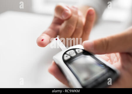 ältere Mann mit Glucometer, die Kontrolle des Blutzuckers Stockfoto