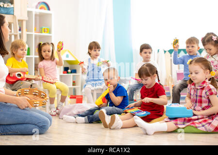 Kindergarten Kinder spielen unterschiedliche musikalische Spielzeug. Frühe musikalische Bildung in Kindertagesstätte Stockfoto