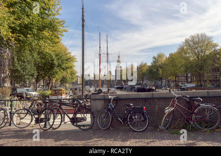 Amsterdam, Niederlande, 09.Oktober 2018: Stadtbild mit Montelbaanstoren Turm Blick von Brücke mit abgestellte Fahrräder Stockfoto