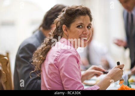 Porträt eines lächelnden Mitte der erwachsenen Frau Essen in einem Restaurant. Stockfoto