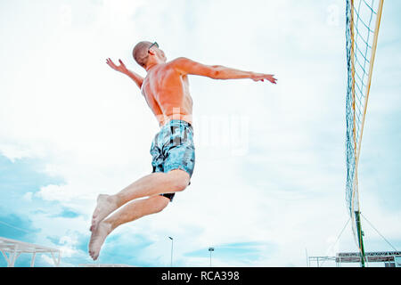 Volleyball beach Player ist ein Athlet Volleyball Spieler fertig, den Ball am Strand zu dienen. Stockfoto
