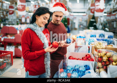 Glückliches Paar wählt Christbaum Kugeln im Supermarkt, Familie Tradition. Dezember shopping Urlaub waren Stockfoto