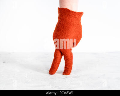 Finger wandern - weibliche Hand in Orange gefilzte Handschuh zeigt wenige Frau auf weißem Hintergrund Stockfoto