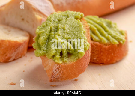 Knusprig leckere Sandwiches aus frischem Baguette mit einer Creme nützlich avacado Creme auf einer gehackten Board. Mit verstreuten Krümel Stockfoto