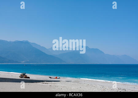 Azurblauen Wasser des Pazifischen Ozeans über die Kiesel Strand mit zentralen Bergkette im Hintergrund, Chisingtan Scenic Area, Hualien, Taiwan Stockfoto