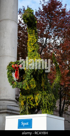 New York City, Vereinigte Staaten - 17. November 2018: eine Hecke Formgehölze geformt wie ein Dinosaurier Holding a Christmas Wreath außerhalb des American Museum der Natu Stockfoto