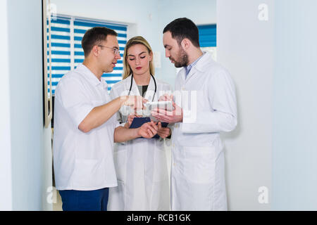 Hohe Betrachtungswinkel von drei Ärzte in weißen Kitteln in Gespräch am Krankenhaus Halle Stockfoto