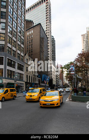 New York City, Vereinigte Staaten - 17. November 2018: Drei New York gelben Taxis, weg von der Ampel am Central Park West ziehen Stockfoto