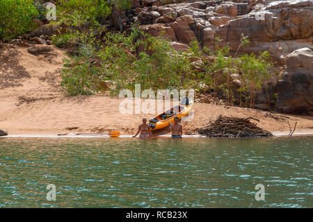 Junges Paar mit Kajak sitzend auf Sandstrand in der Katherine Gorge im Nitmiluk Nationalpark, Katherine, Northern Territory, Top End, Australien Stockfoto