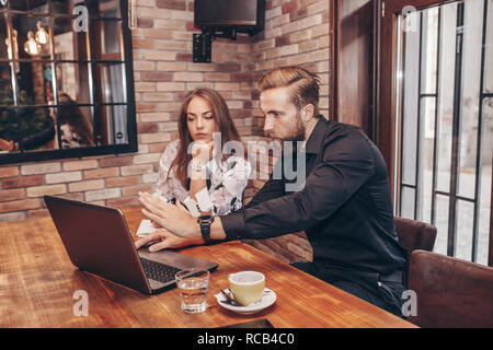 Junge Geschäftsfrau und Mann mit Laptop und ein Gespräch Stockfoto