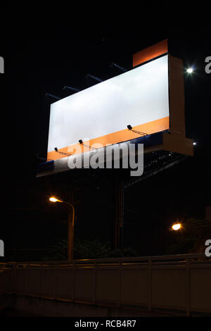 Leere Anzeige Billboard mit weißen Leerzeichen Hintergrund in der Nacht oberhalb der Fußgängerbrücke über der Hauptstraße. Werbung, Außenwerbung, Aus Stockfoto