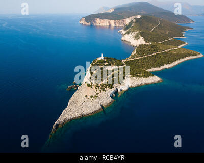 Schmutzige Straße entlang grüne Landschaft zu wunderschönen glänzenden weißen Leuchtturm am Ende einer schönen Insel Cape mit Blick auf das Meer im Hintergrund sichtbar führenden Stockfoto