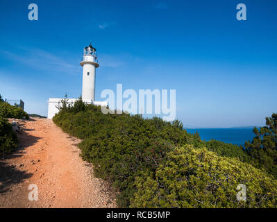 Schmutzige Straße entlang grüne Landschaft zu wunderschönen glänzenden weißen Leuchtturm am Ende einer schönen Insel Cape mit Blick auf das Meer im Hintergrund sichtbar führenden Stockfoto