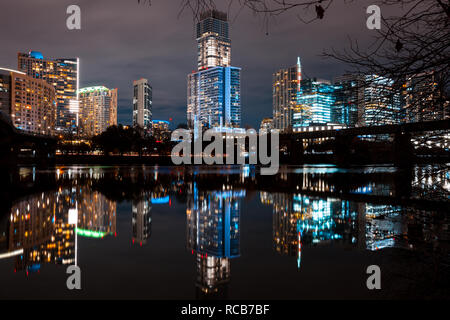 Austin Skyline bei Nacht mit hell beleuchteten Gebäuden in Lady Bird Lake widerspiegelt Stockfoto